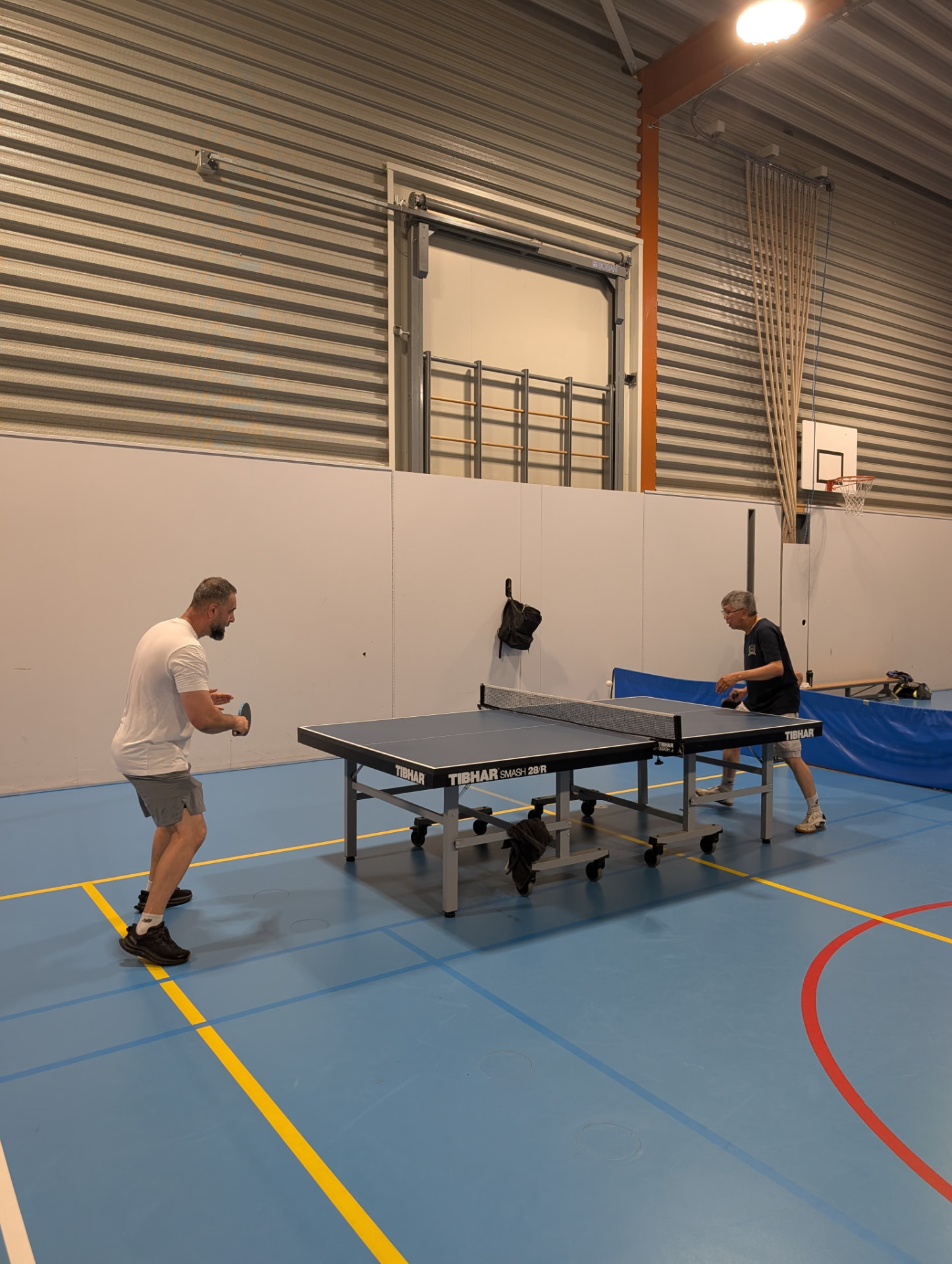A wide view of a match in full swing on the blue courts at Sportcentrum Caland