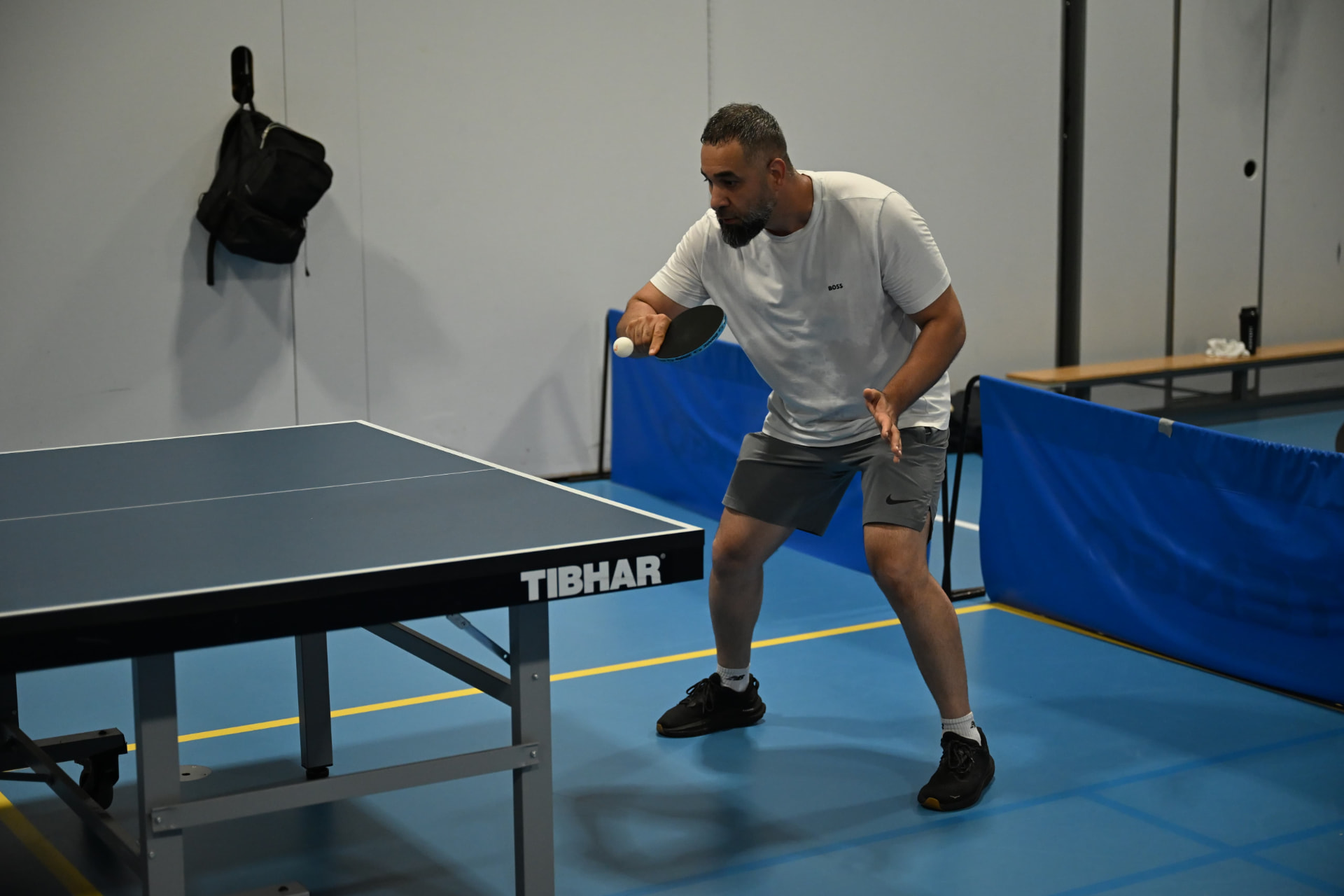 A member in a ready stance, focused on the incoming ball