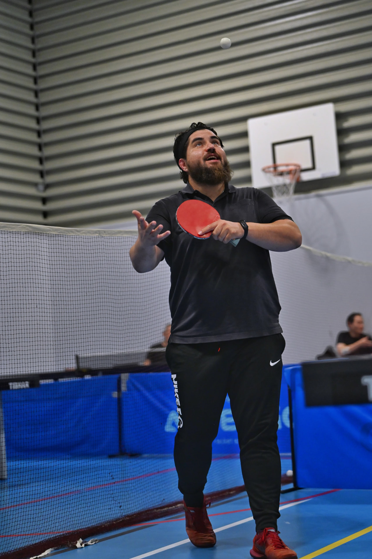 A player tossing the ball high as he practises his serve