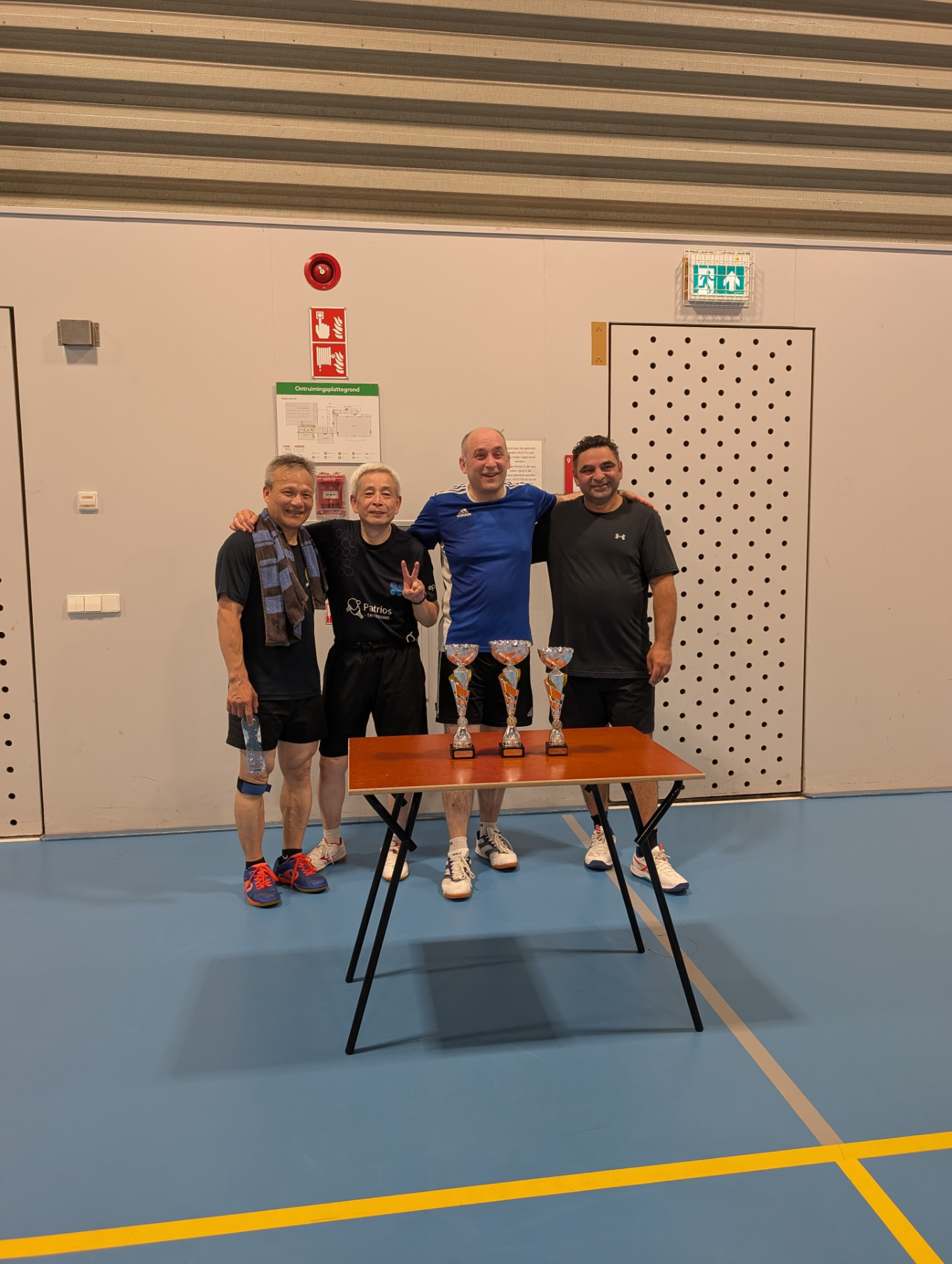 Four club members posing behind the trophy table after a club tournament